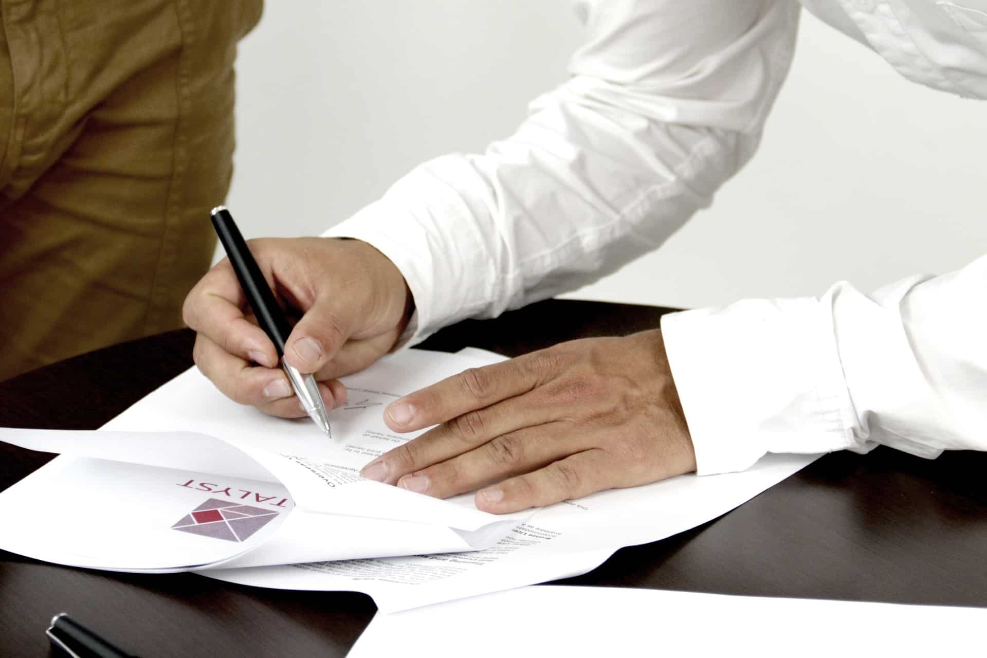 אדם מחזיק עט לצורך בדיקת מסמכים